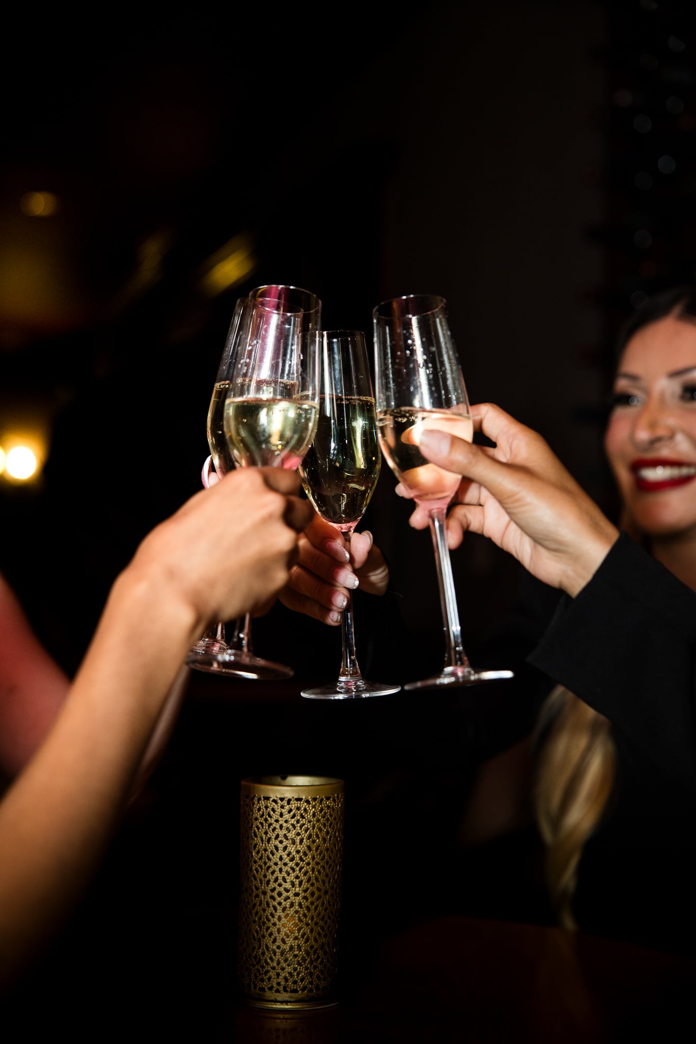 A champagne toast in the low-lit Tiffany Lounge source media environment.